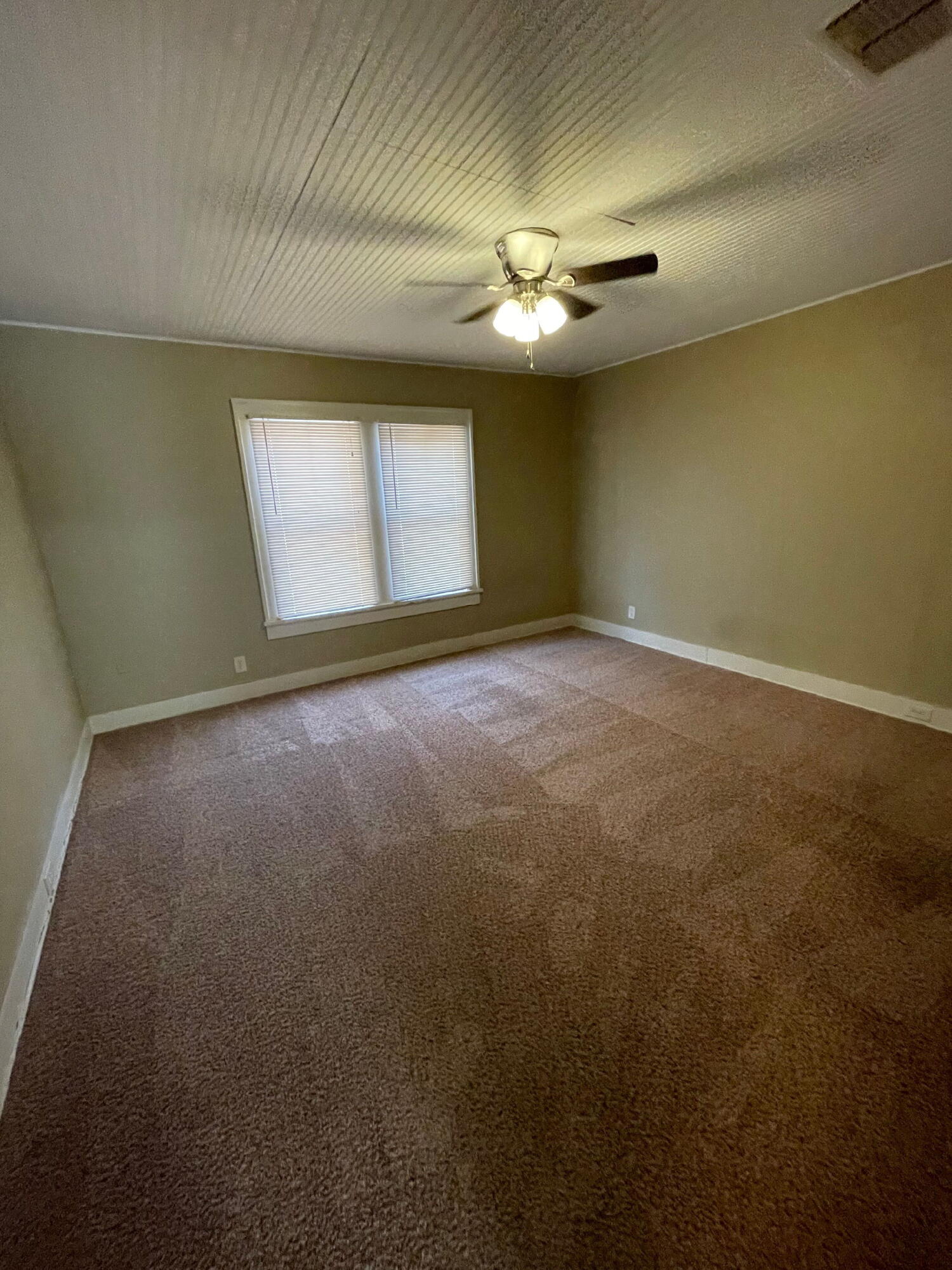 2111 14th Street Lubbock, TX 79401 - Photo 6 of 10 an empty room with windows and fan