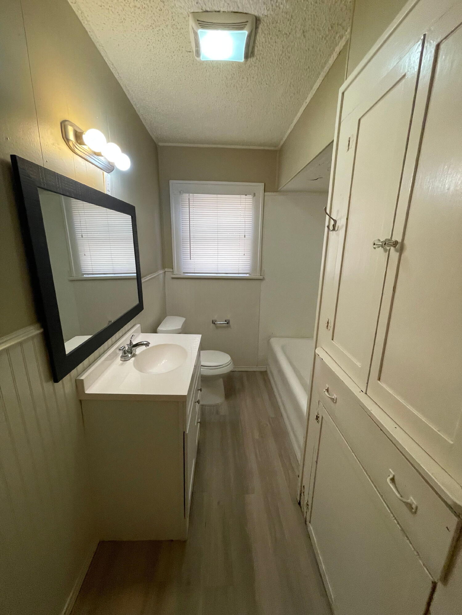 2111 14th Street Lubbock, TX 79401 - Photo 7 of 10 a bathroom with a sink a toilet and mirror