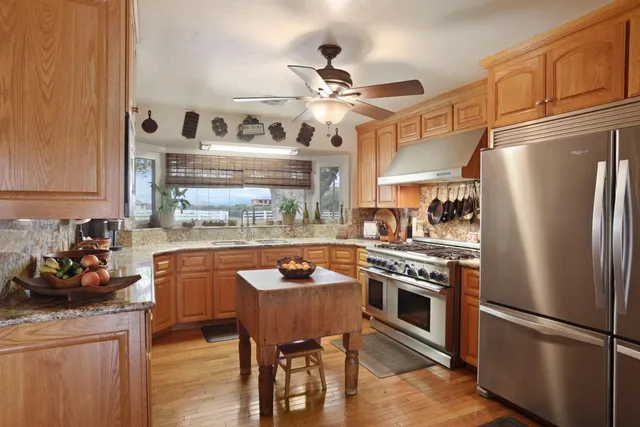 a kitchen with stainless steel appliances granite countertop a stove refrigerator and cabinets