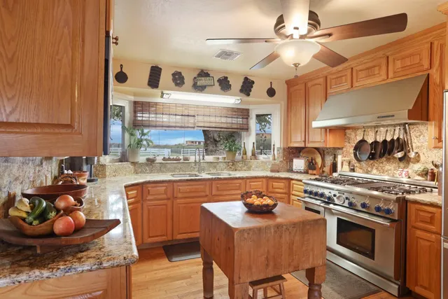 a dining room with wooden floor a chandelier fan a wooden floor and a chandelier