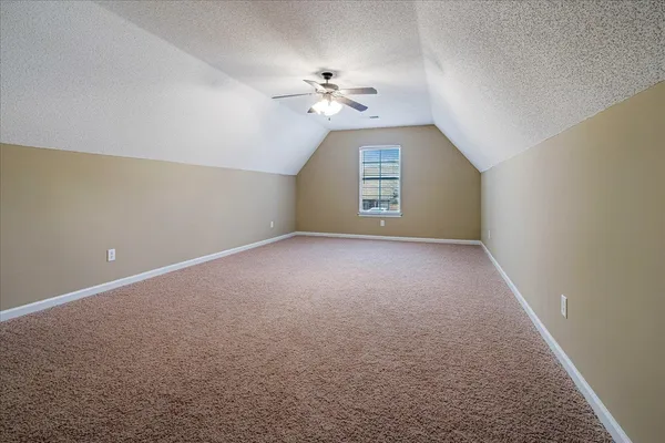 a view of a big room with windows and chandelier fan