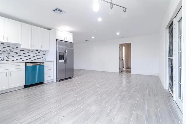 a view of a kitchen with a sink and a refrigerator