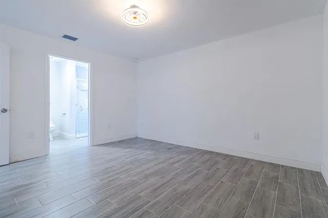 a view of an empty room and wooden floor
