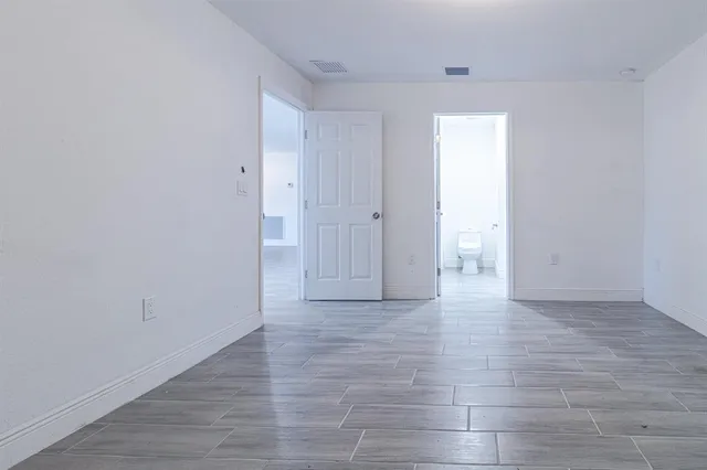 a view of an empty room and wooden floor