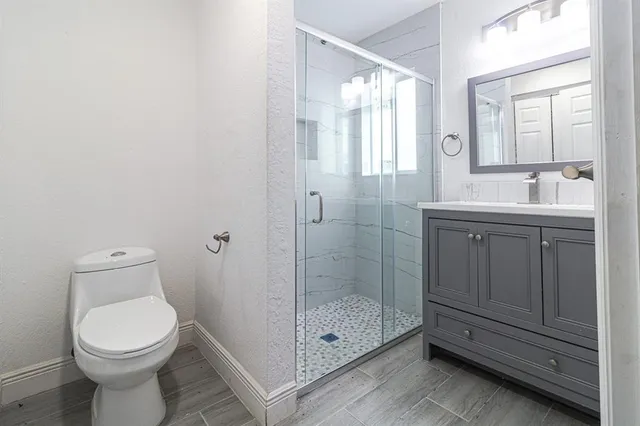 a bathroom with a toilet a sink and glass door