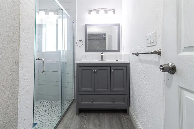 a bathroom with a sink a toilet and shower