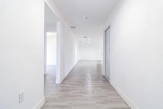 a view of a hallway with wooden floor