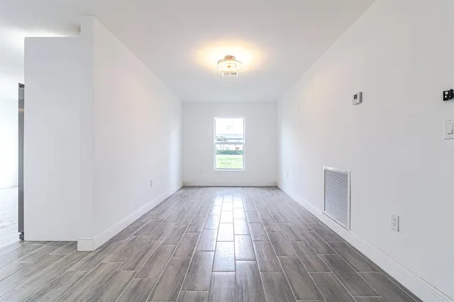 wooden floor in an empty room with a window