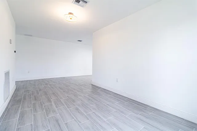 a view of an empty room with wooden floor
