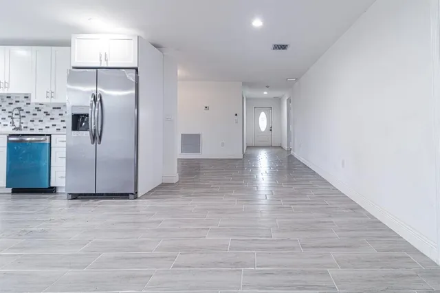 a view of a kitchen with a sink and refrigerator