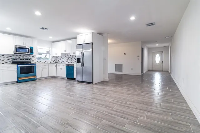 a kitchen with stainless steel appliances granite countertop a refrigerator and a stove top oven