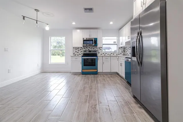 a kitchen with a refrigerator and a stove top oven