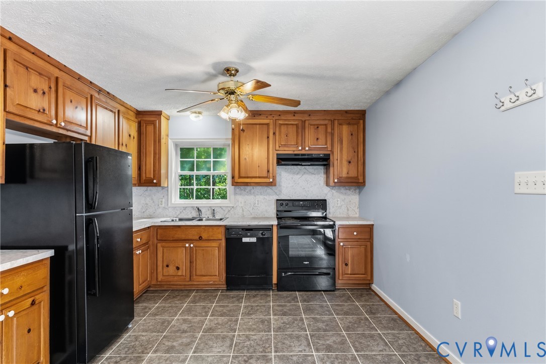 12654 Mt Olive Cohoke Road West Point, VA 23181 - Photo 12 of 31 a kitchen with stainless steel appliances a stove a sink and a refrigerator