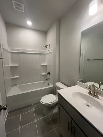 a bathroom with a sink a toilet a mirror and shower