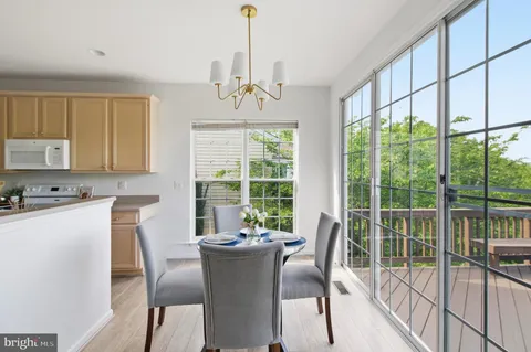 a dining room with furniture a chandelier and wooden floor