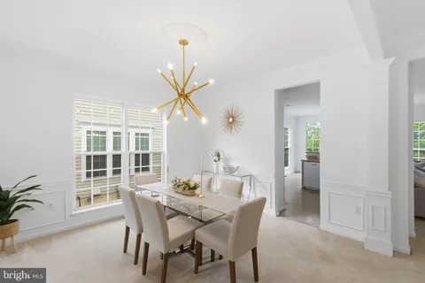 a dining room with furniture a chandelier and wooden floor