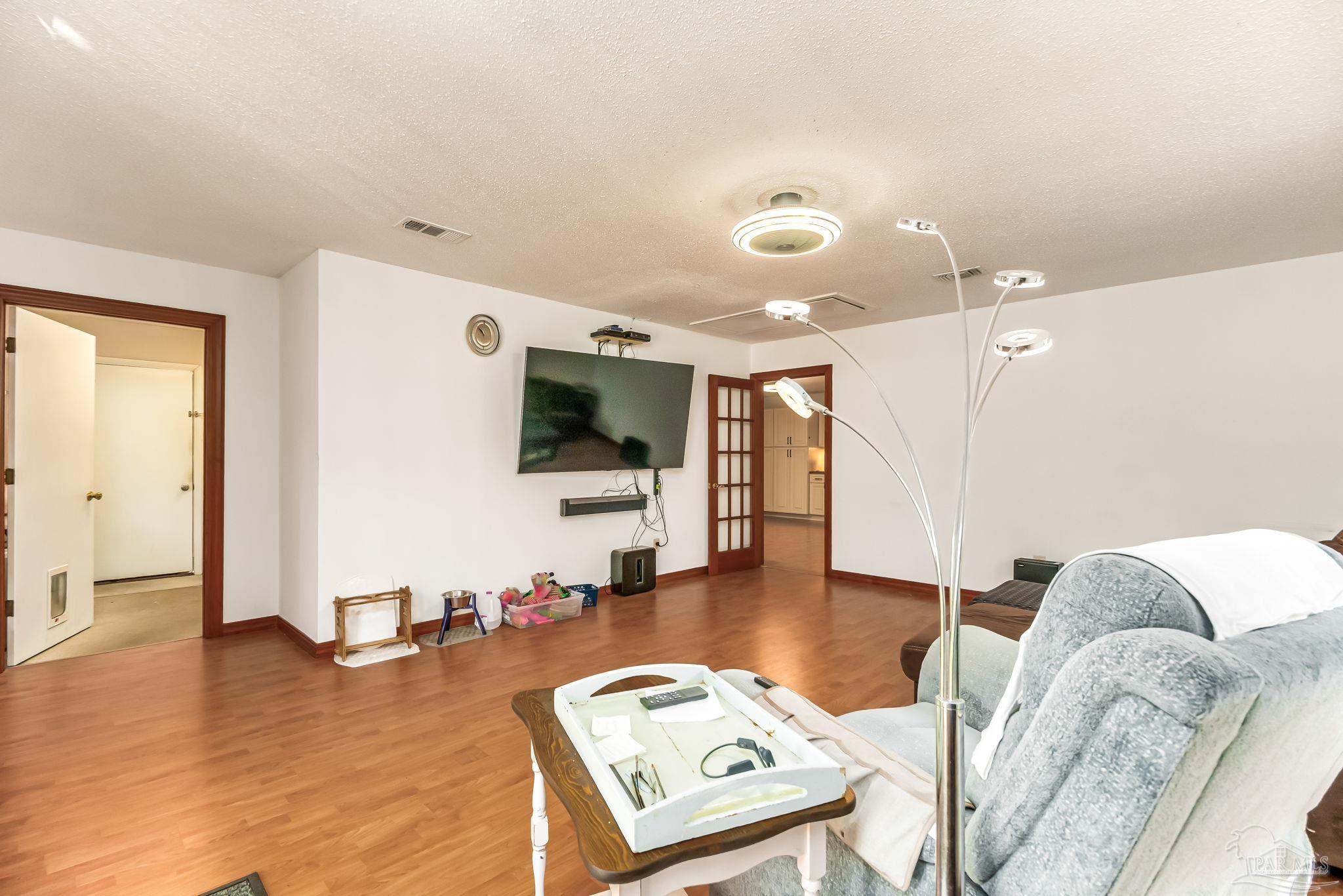 4640 Bessinger Lane Pace, FL 32571 - Photo 15 of 54 a living room with furniture and a flat screen tv