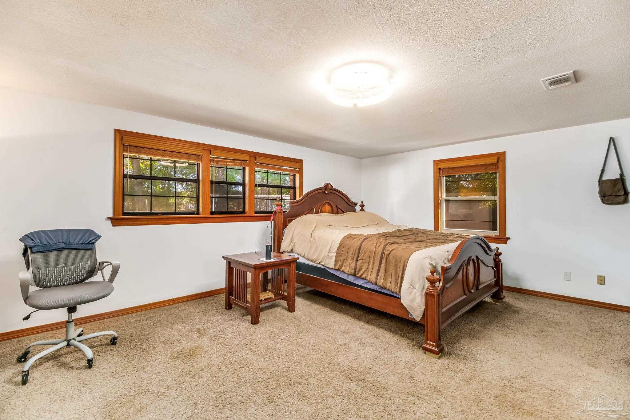 4640 Bessinger Lane Pace, FL 32571 - Photo 17 of 54 a bedroom with a bed and chair