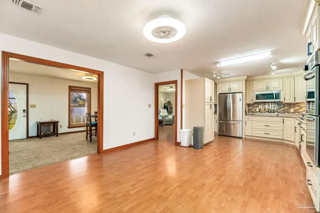 a view of a kitchen with refrigerator and cabinets