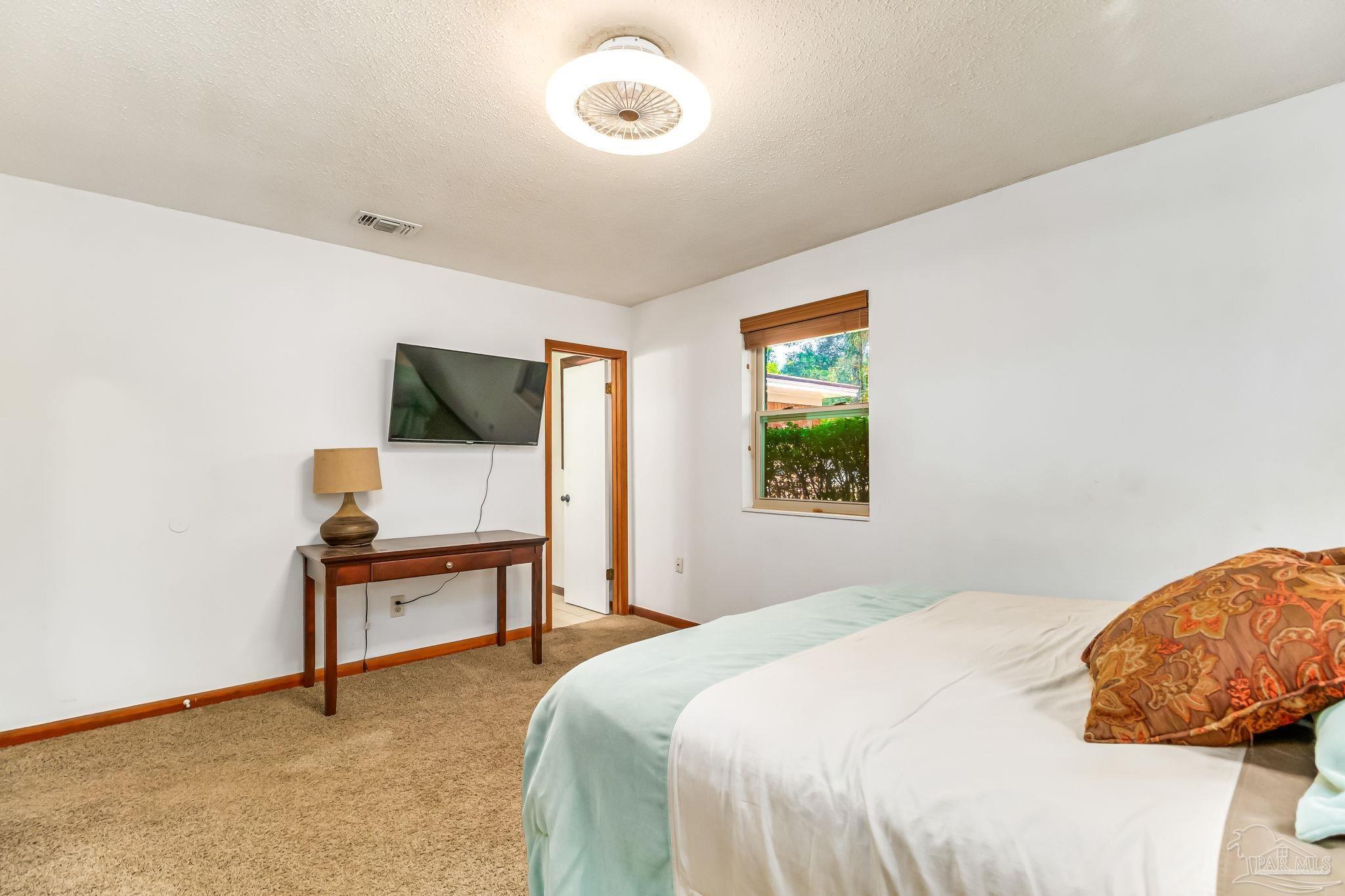 4640 Bessinger Lane Pace, FL 32571 - Photo 25 of 54 a bedroom with a bed table chair and a window