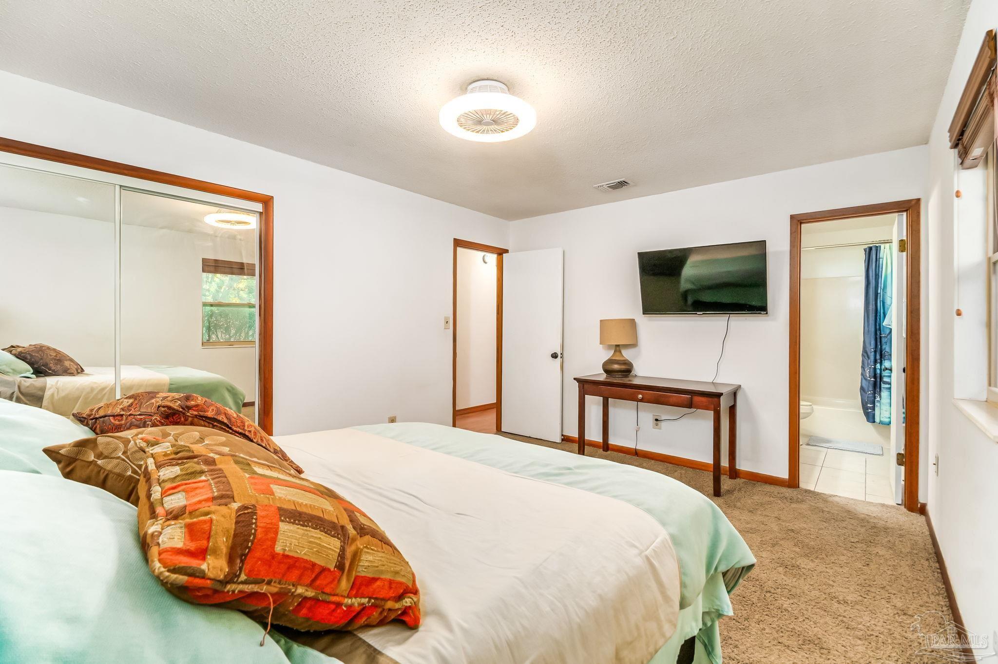 4640 Bessinger Lane Pace, FL 32571 - Photo 26 of 54 a bedroom with a bed and a flat tv screen tv