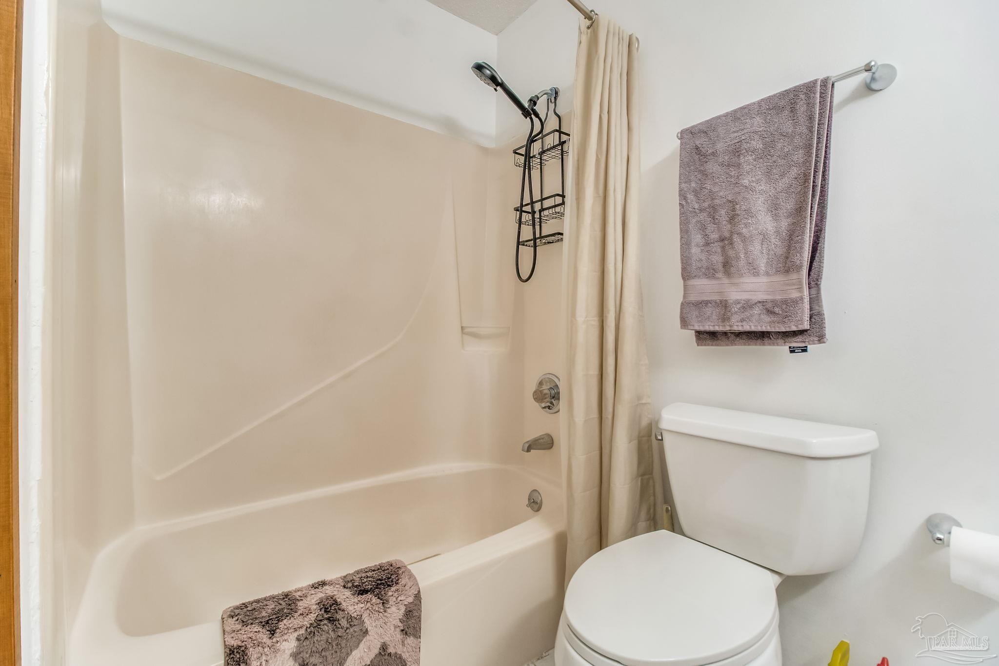 4640 Bessinger Lane Pace, FL 32571 - Photo 29 of 54 a white toilet sitting next to a bath tub and a shower