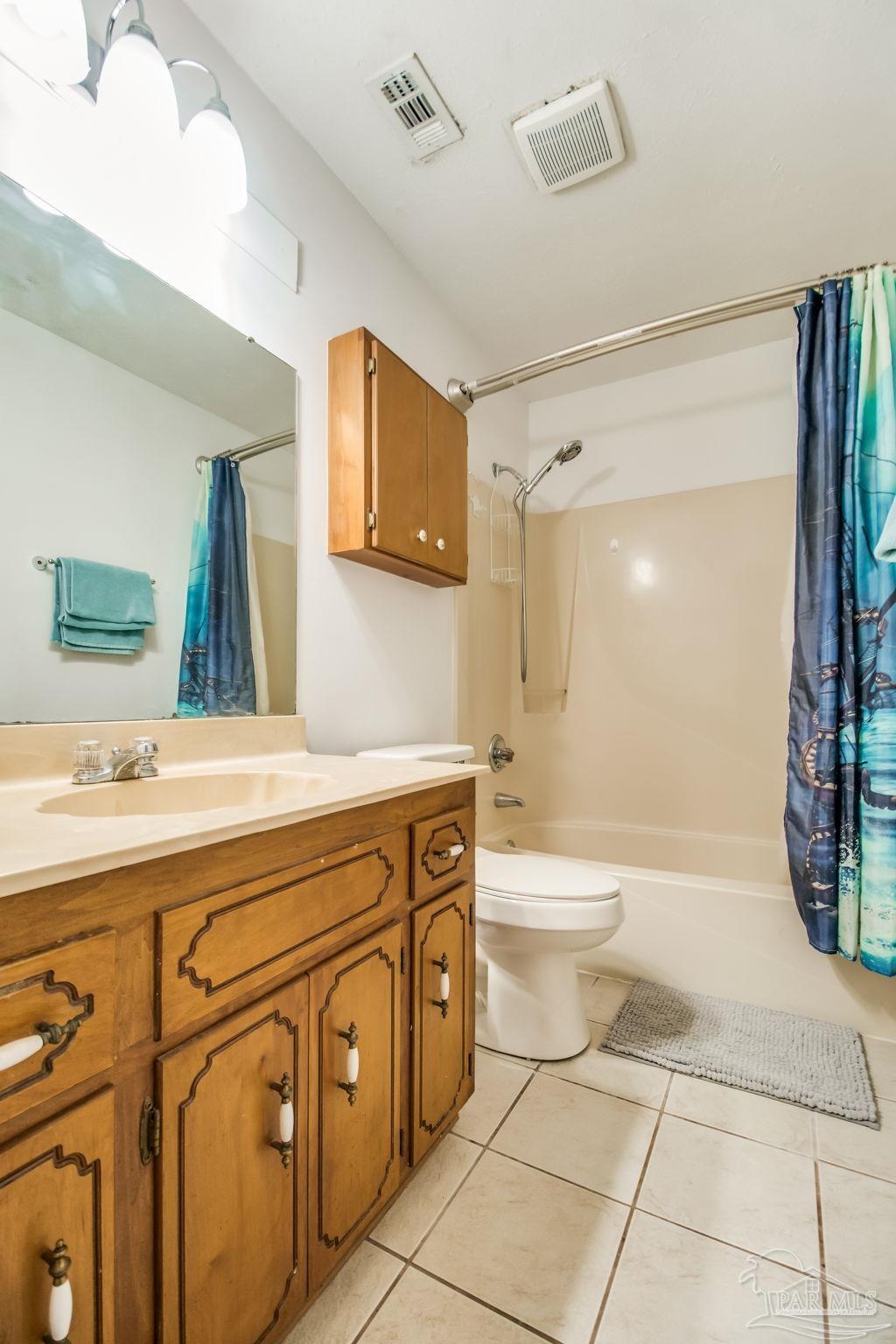 4640 Bessinger Lane Pace, FL 32571 - Photo 31 of 54 a bathroom with a granite countertop sink toilet a mirror and bathtub