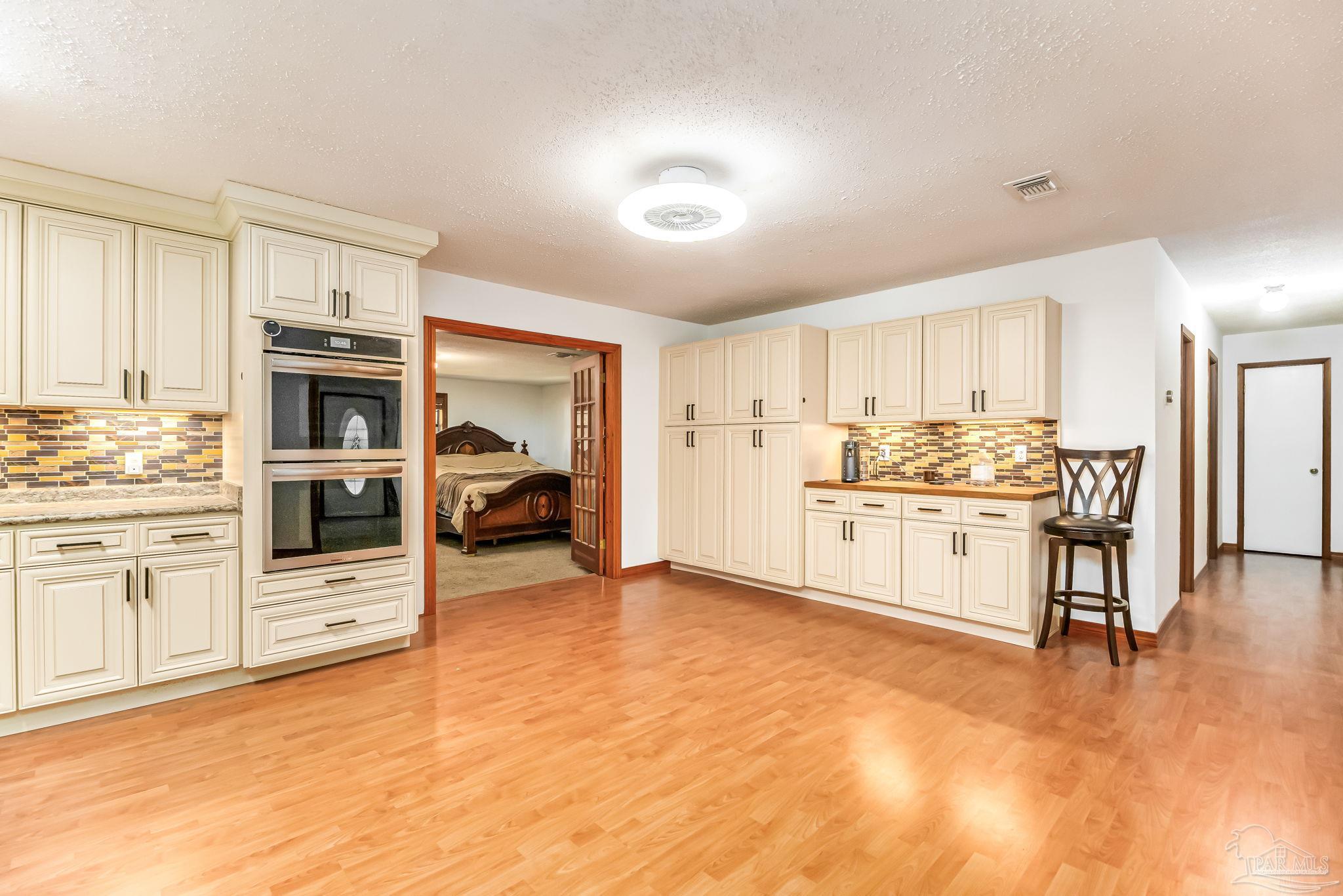 4640 Bessinger Lane Pace, FL 32571 - Photo 4 of 54 a kitchen with white cabinets and stainless steel appliances