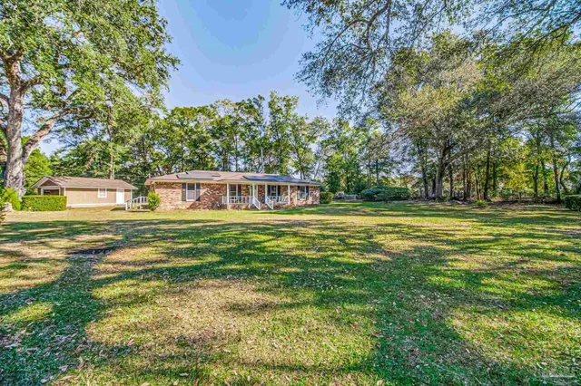 a view of a house with backyard and sitting area