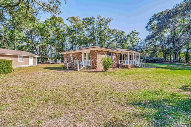 a front view of a house with a garden and yard
