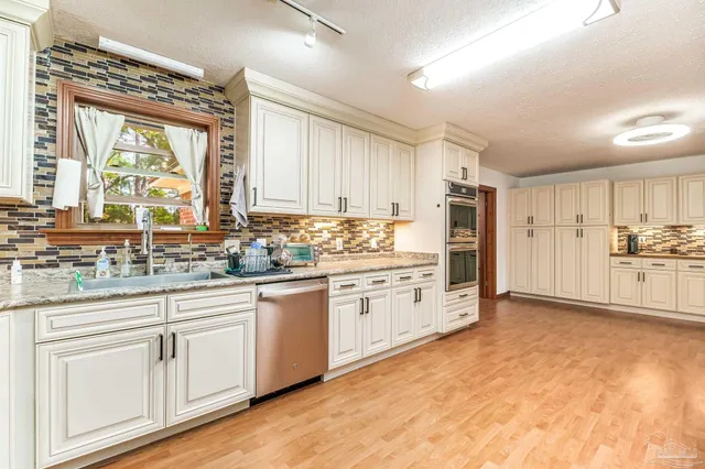 a kitchen with granite countertop white cabinets and white appliances