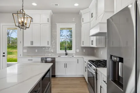 a kitchen with a sink a window and stainless steel appliances
