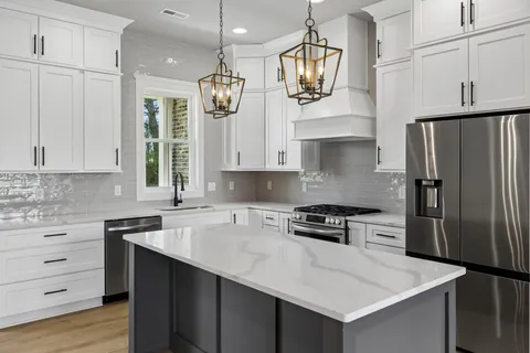 a kitchen with stainless steel appliances a stove a sink and a refrigerator