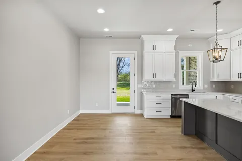 a view of a kitchen with wooden floor and a sink