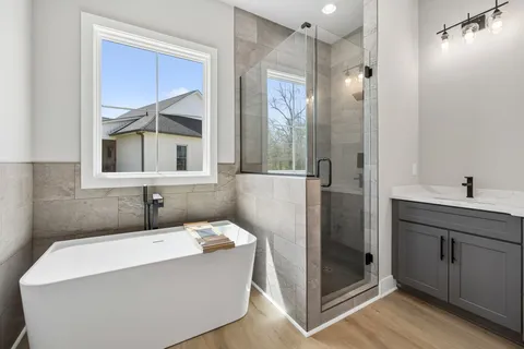 a bathroom with a tub a sink and mirror