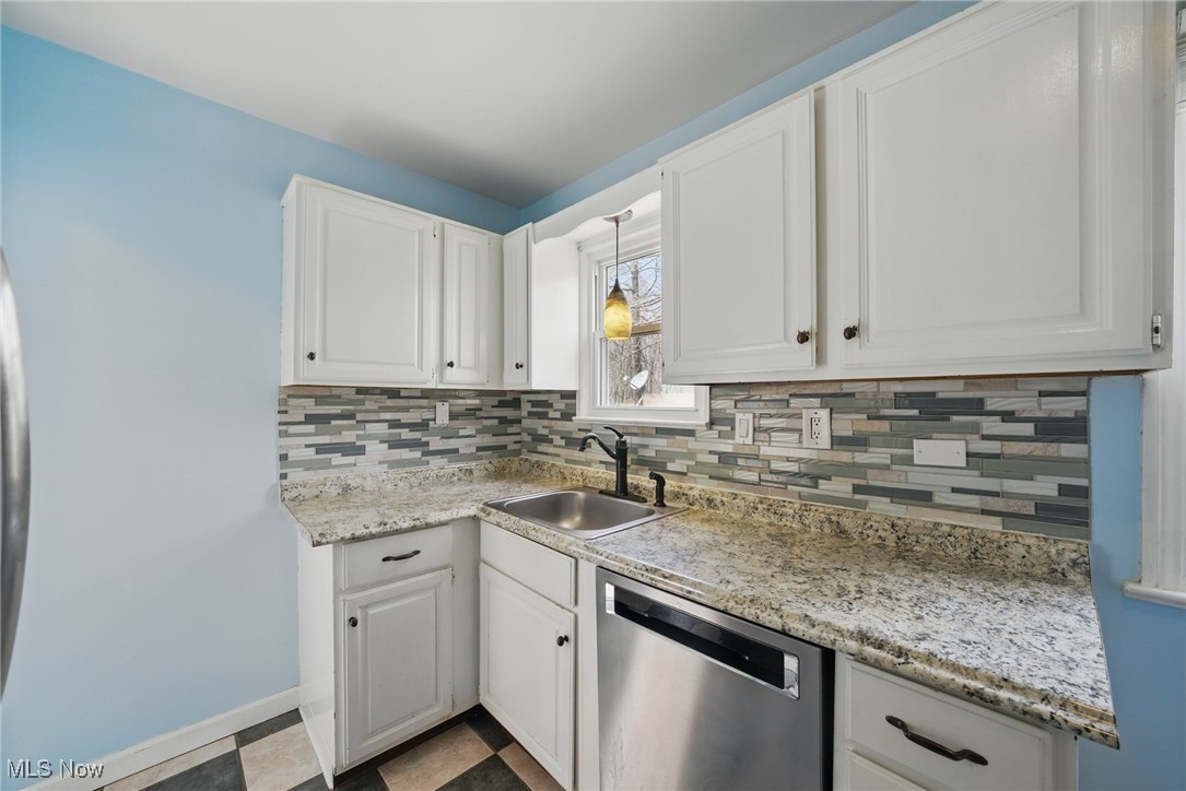 28575 White Road Wickliffe, OH 44092 - Photo 11 of 49 Kitchen with stainless steel dishwasher, white cabinets, a sink, and decorative backsplash