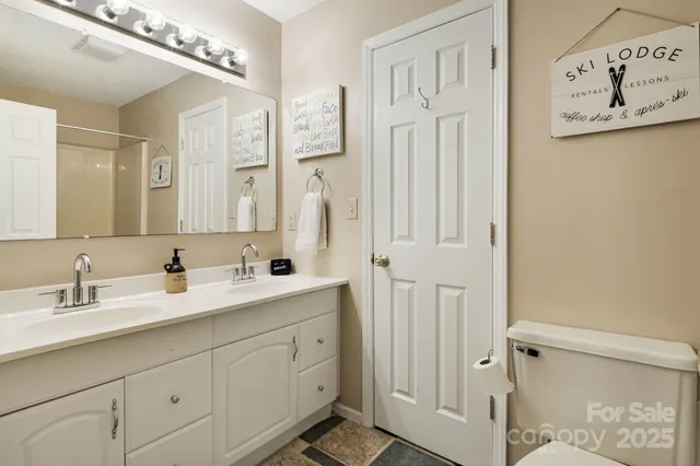 a bathroom with a double vanity sink a mirror and a shower