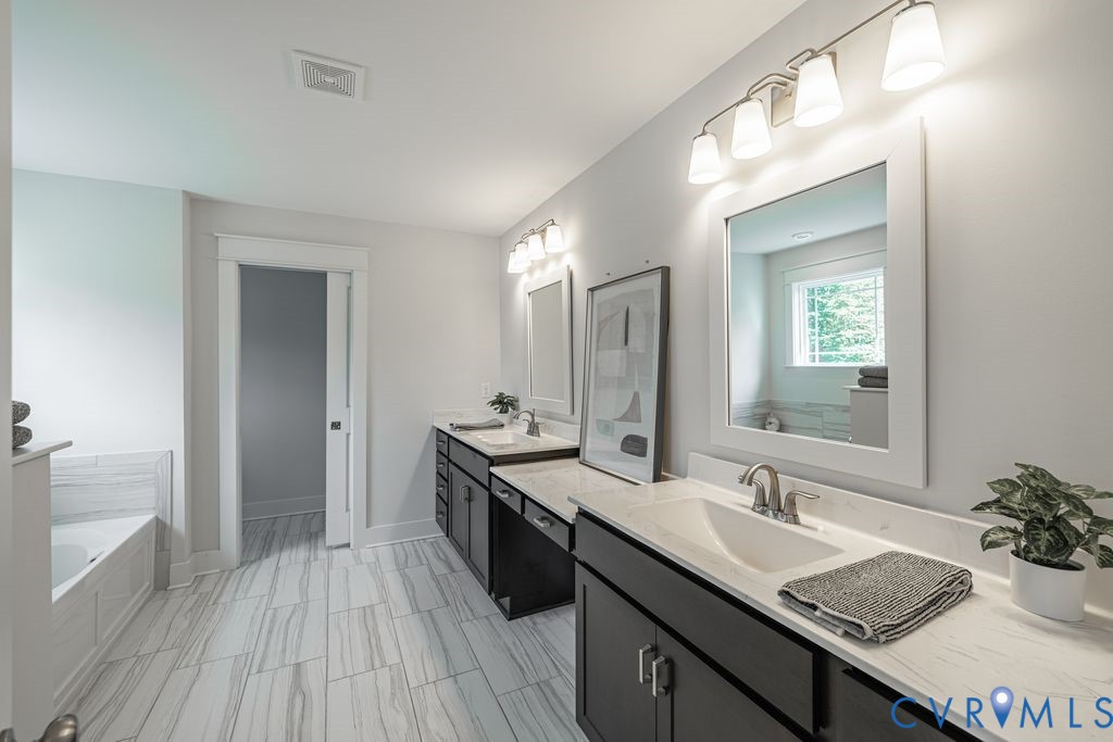 9377 Magnolia Blossom Road Ashland, VA 23005 - Photo 36 of 49 a bathroom with a sink double vanity granite tub and shower