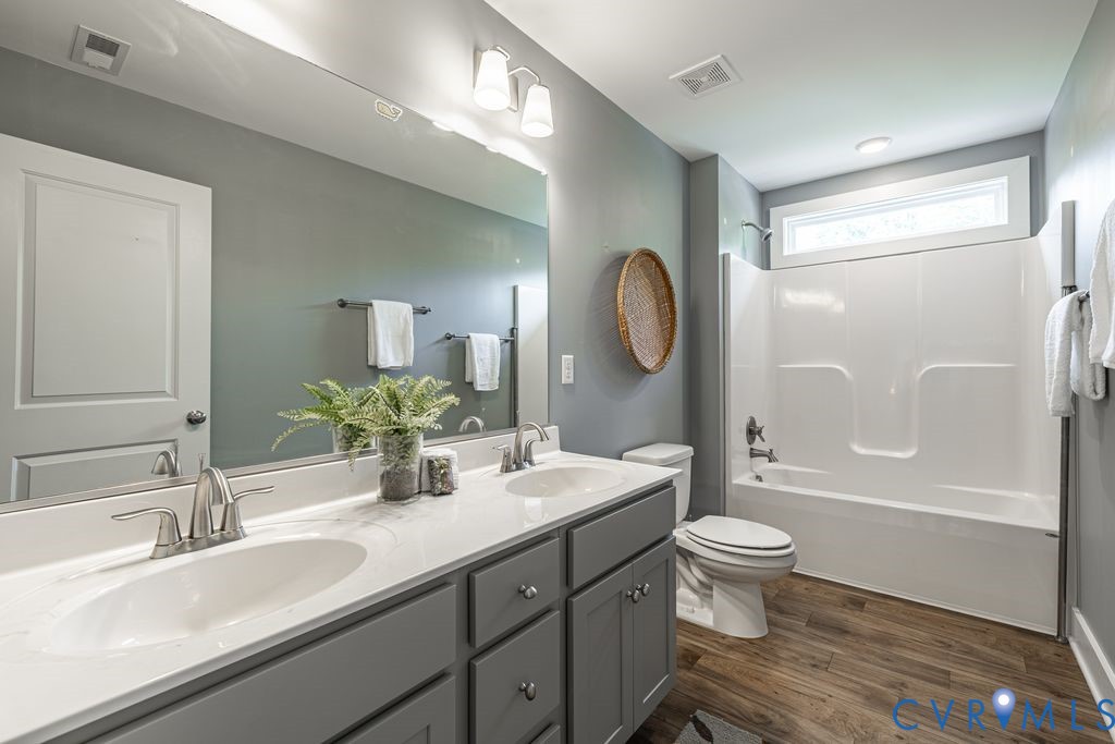 9377 Magnolia Blossom Road Ashland, VA 23005 - Photo 39 of 49 a bathroom with a double vanity sink toilet mirror and bathtub