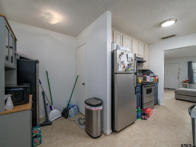 a kitchen with stainless steel appliances granite countertop a refrigerator and a sink