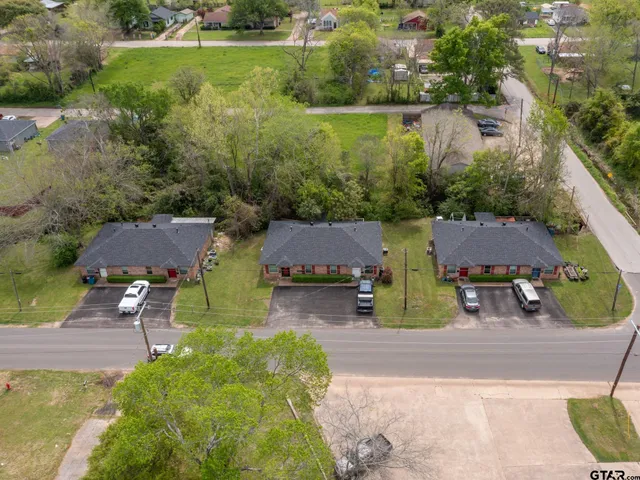 an aerial view of multiple houses with yard