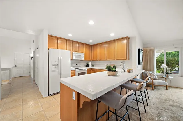 a kitchen with stainless steel appliances kitchen island granite countertop a refrigerator a stove a microwave oven with a dining table and chairs