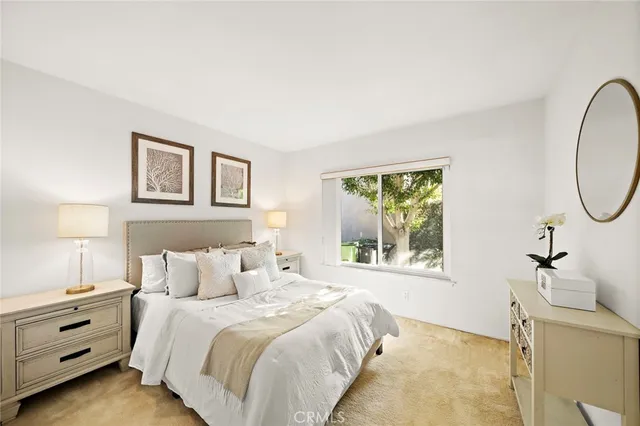 a bedroom with a bed a lamp and a window