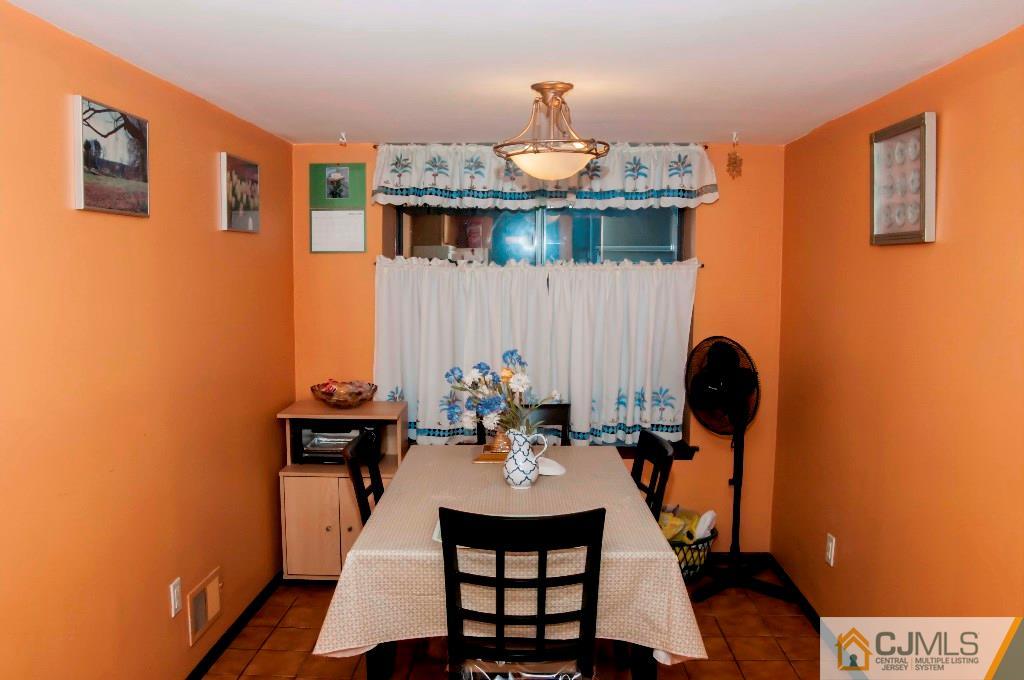 5802 Hana Road Edison, NJ 08817 - Photo 5 of 17 a dining room with furniture a chandelier and wooden floor