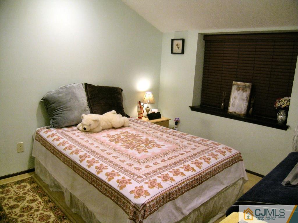5802 Hana Road Edison, NJ 08817 - Photo 9 of 17 a bedroom with a bed and a flat tv screen on dresser