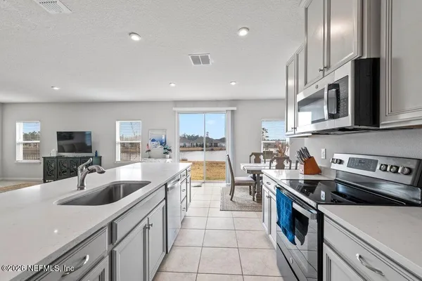 a kitchen with stainless steel appliances granite countertop a sink a stove and a refrigerator