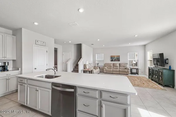 a kitchen with sink a microwave and cabinets