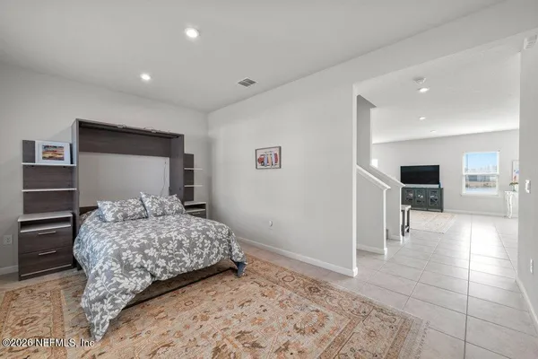 a bedroom with a large bed and a view of kitchen