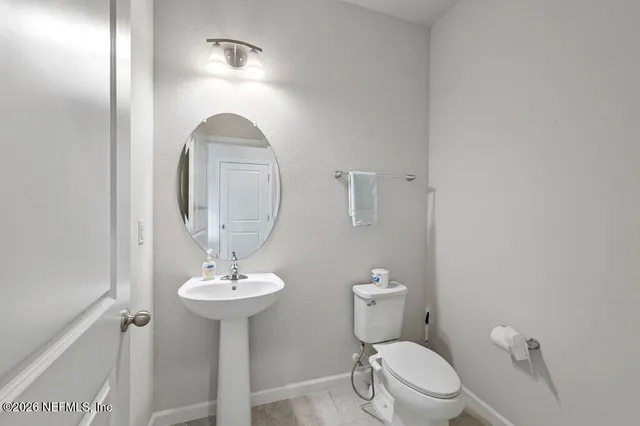 a bathroom with a toilet a sink and a mirror