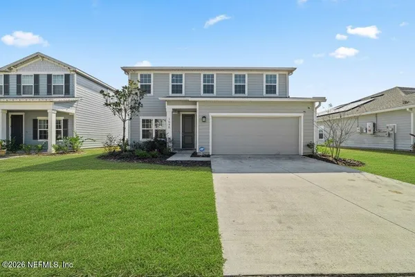 a front view of a house with a yard and garage